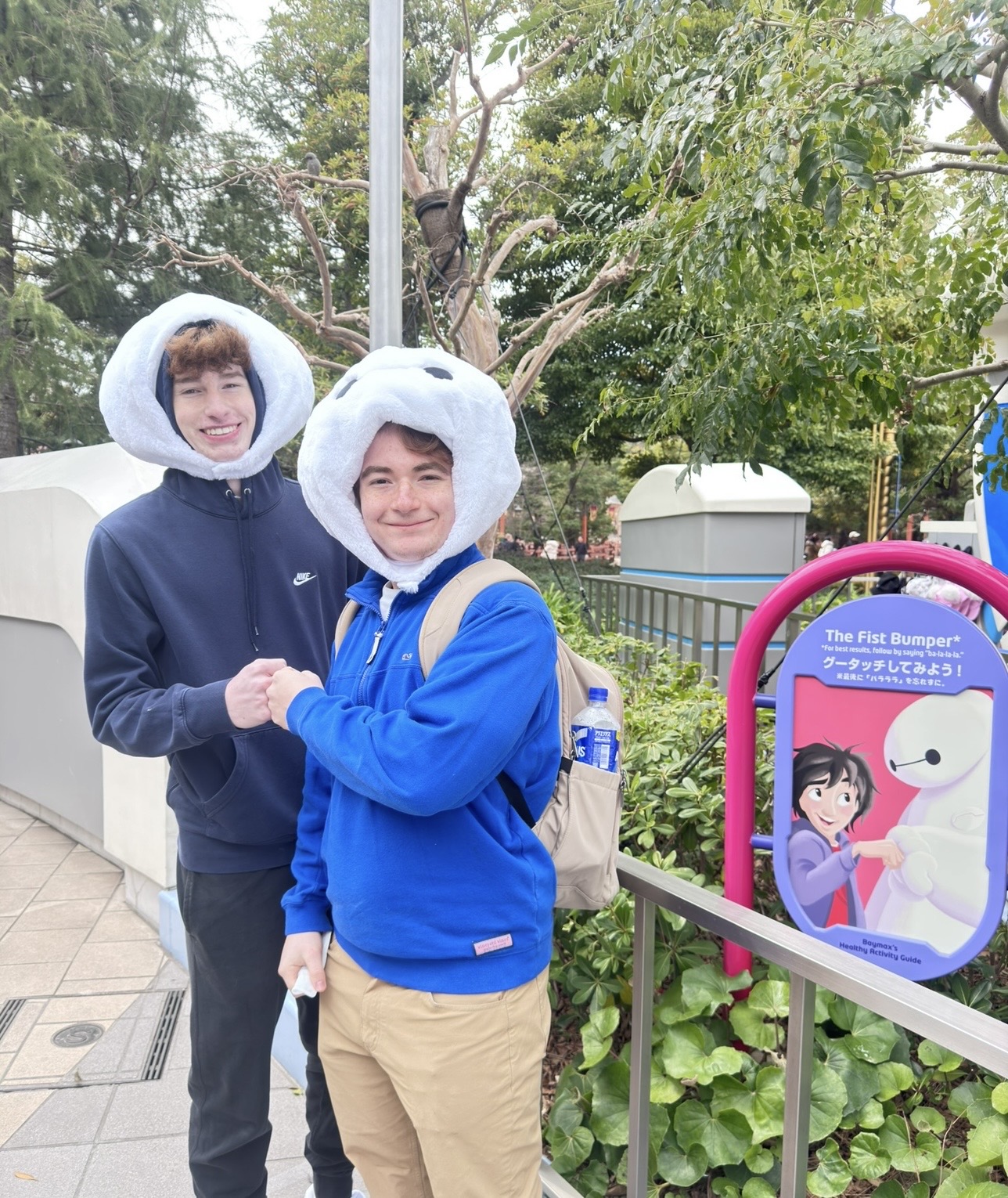 Both boys in Baymax hats fist bump